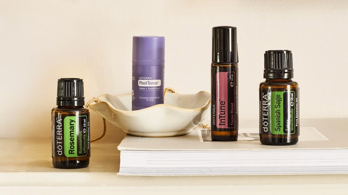 Fokus und Loslassen: dōTERRA Rosmarin, PastTense Stick, InTune Roll-on und Spanischer Salbei auf einem hellen Regal